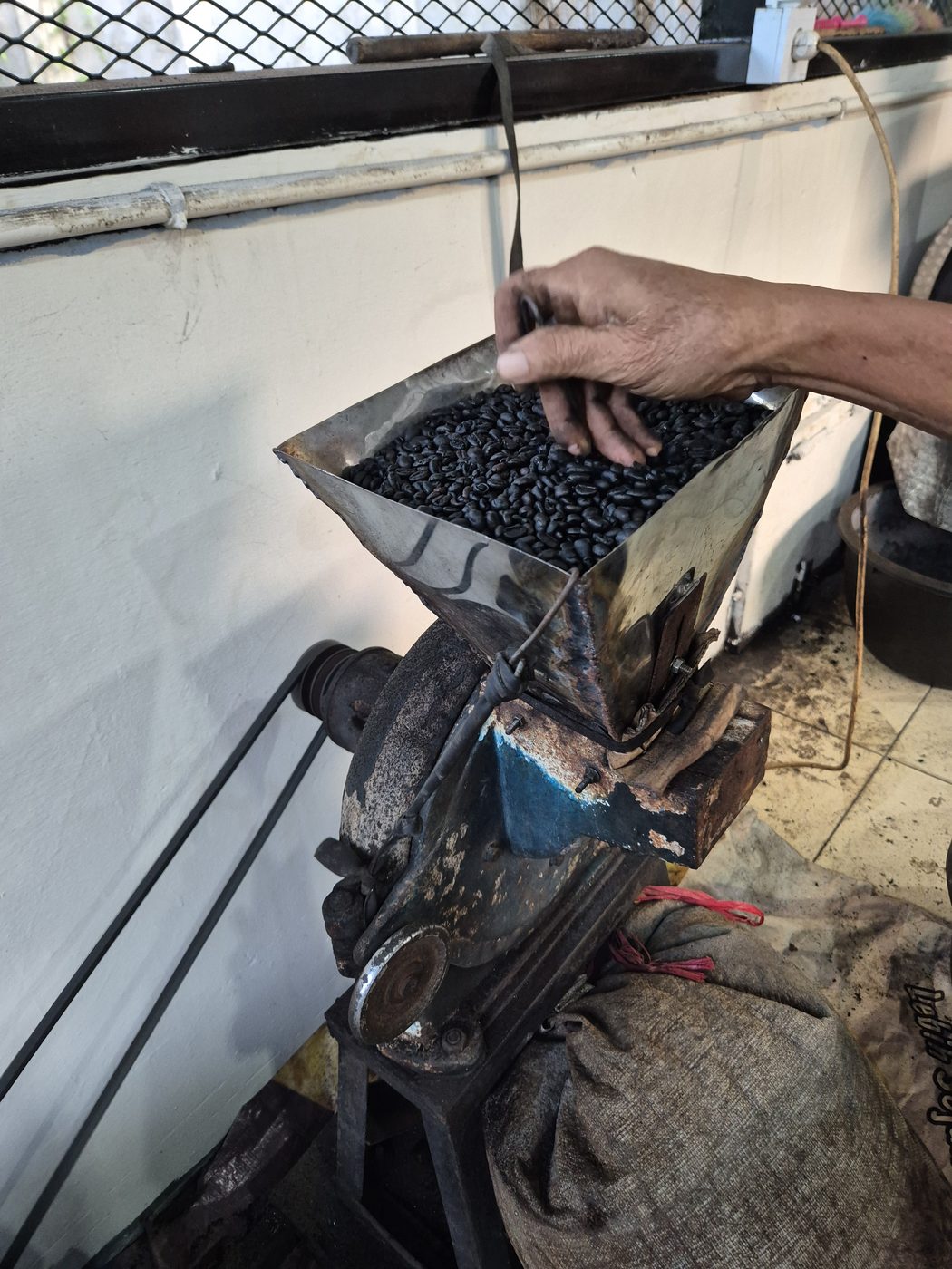Kopi digiling dengan alat lama Kedai Kopi Nirwana