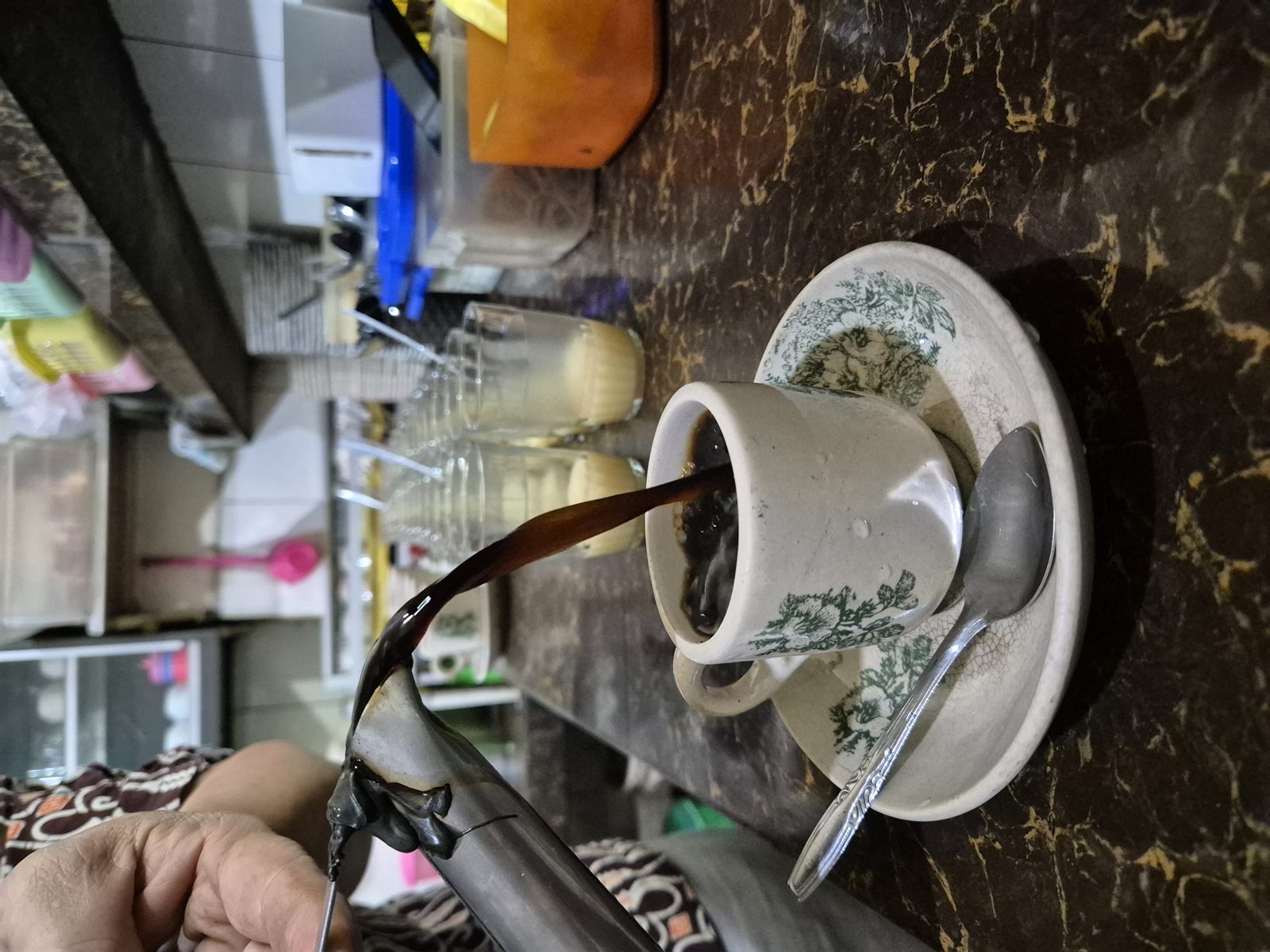 Kopi hitam panas sedang dituangkan ke dalam cangkir Kedai Kopi Nirwana